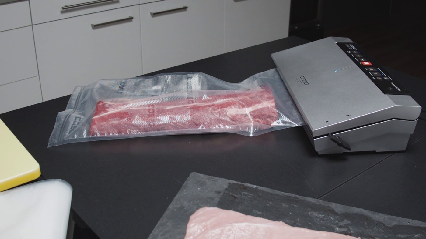 Meat being vacuum sealed with a machine to preserve it for later use.