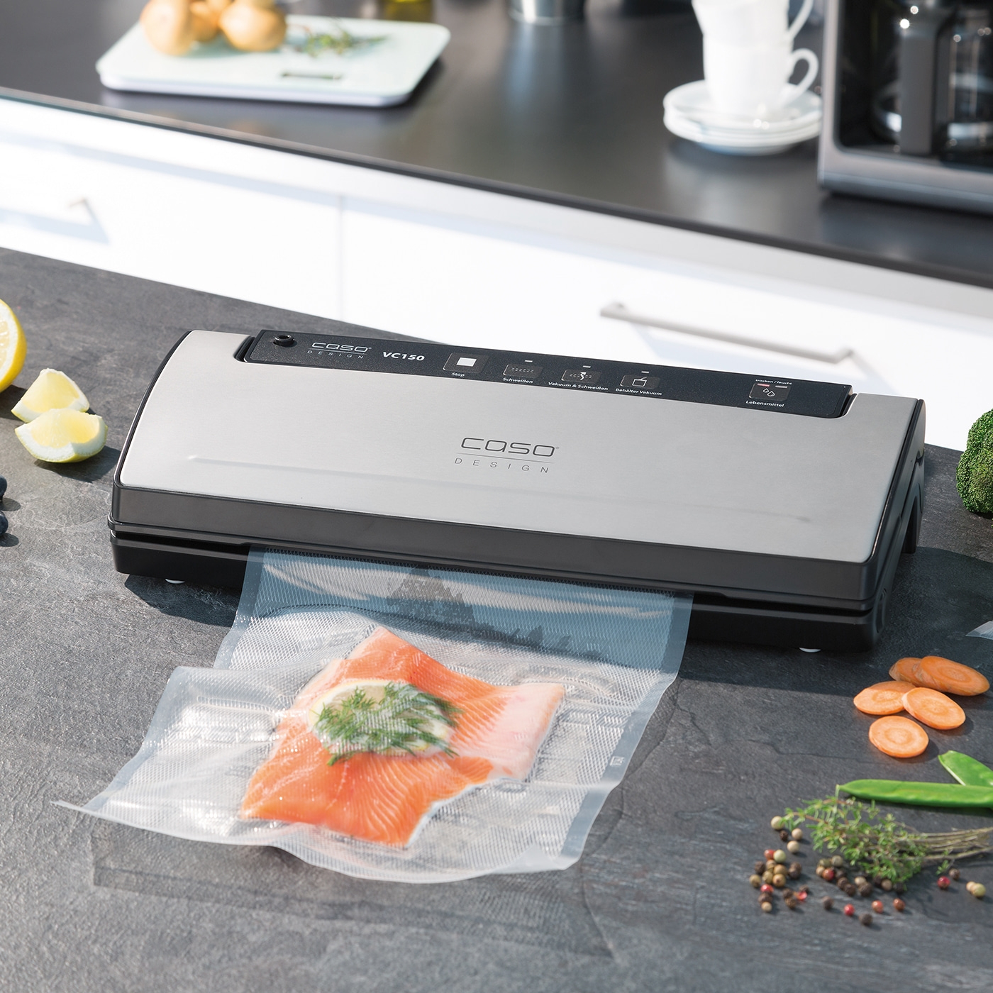 Vacuum sealer with fish and vegetables on a kitchen countertop, close-up shot.