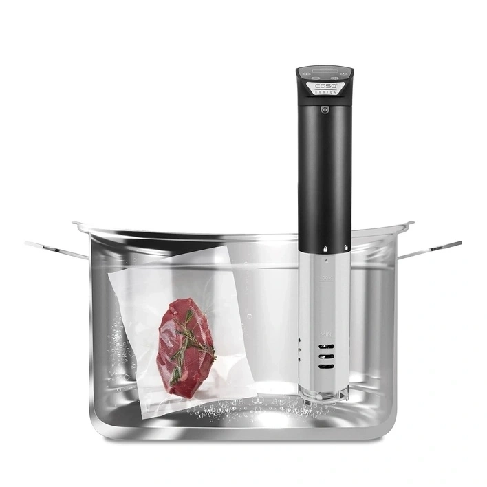 Sous vide machine with meat in water bath, ready for cooking.