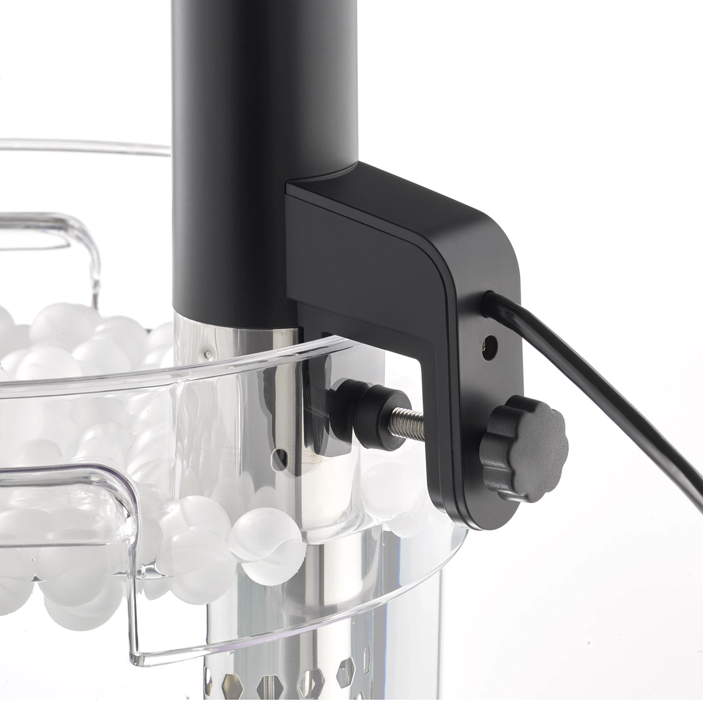 Schwarzes Gerät mit Kabel und Schraube, um einen Behälter zu befestigen, gefüllt mit weißen Kugeln.