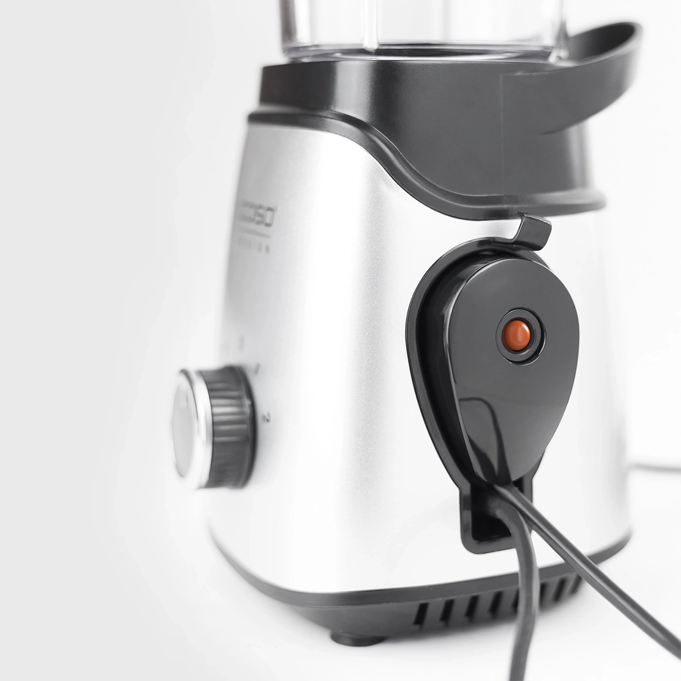 Close-up of a silver blender with a black button and power cord.