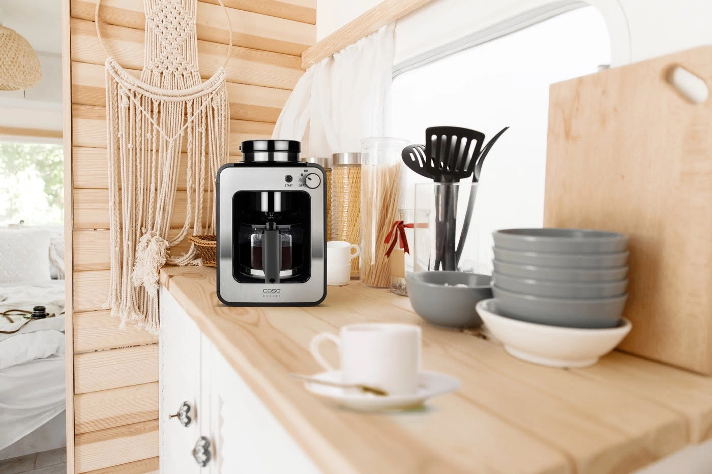 Kaffeemaschine auf einer Holzoberfläche mit Küchenutensilien und Dekoration