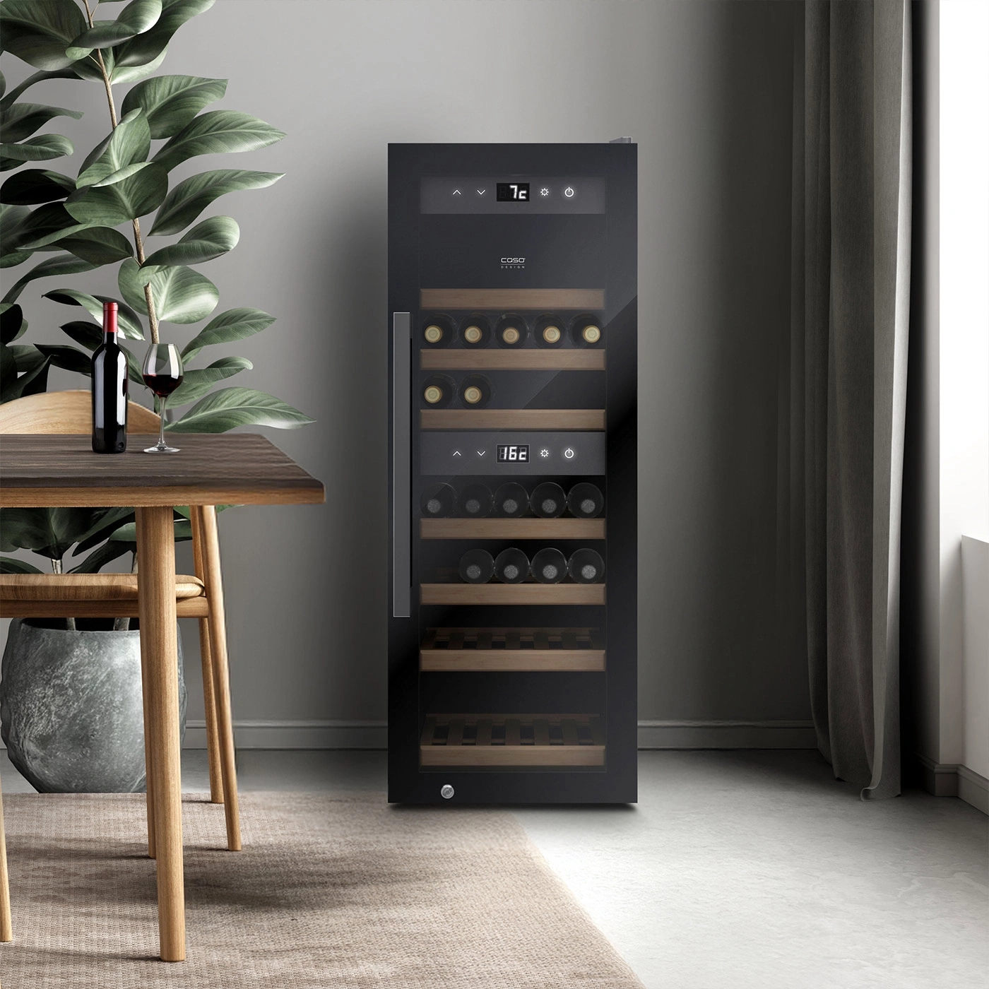 Ein moderner schwarzer Weinkühlschrank mit Holzböden und Glasfront steht neben einem Esstisch mit einer Flasche Wein und einem Glas.
