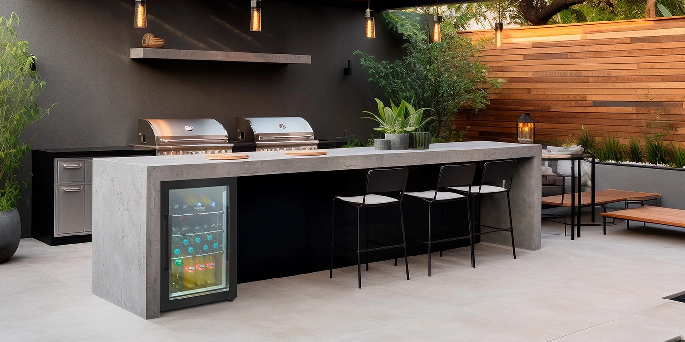 Modern outdoor kitchen with grill, bar, and outdoor seating area.