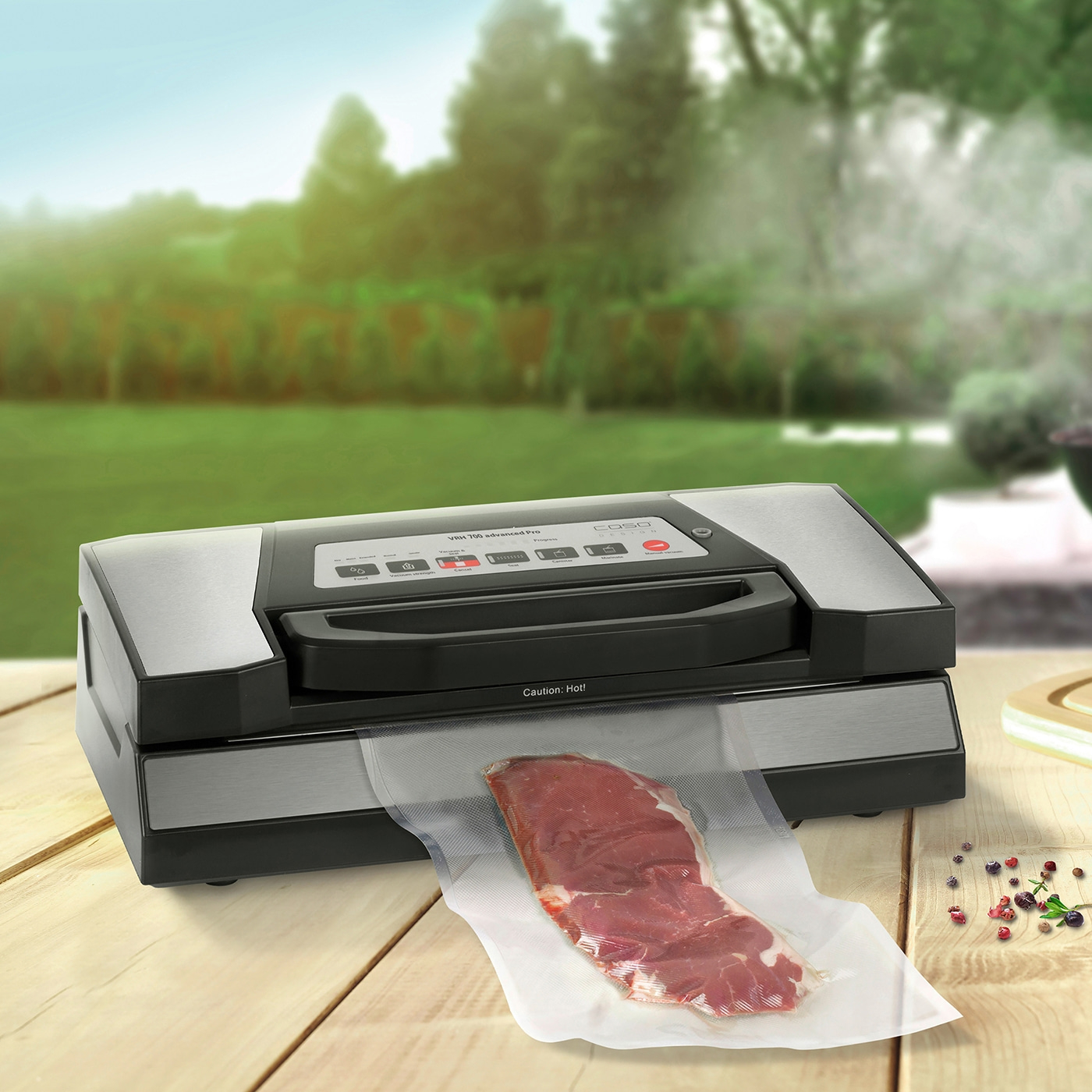 Vacuum sealer with meat on a wooden table outdoors in the garden