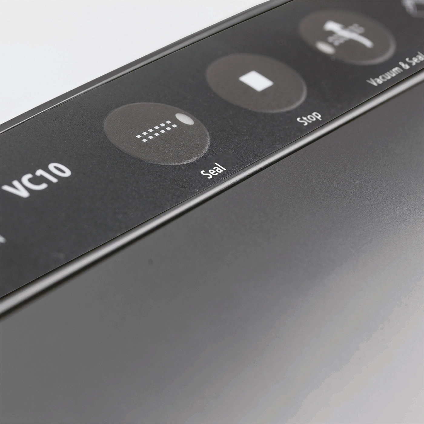 Close-up of a vacuum sealer's control panel, featuring 'Seal' and 'Stop' buttons.