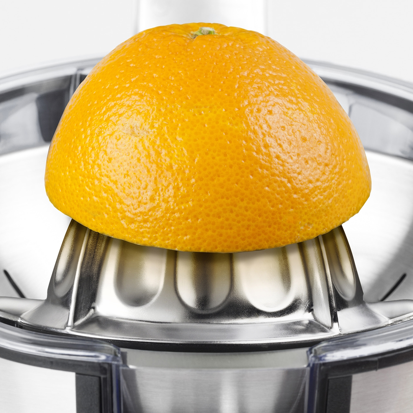 Close-up of an orange on a citrus juicer, ready to be squeezed for juice.