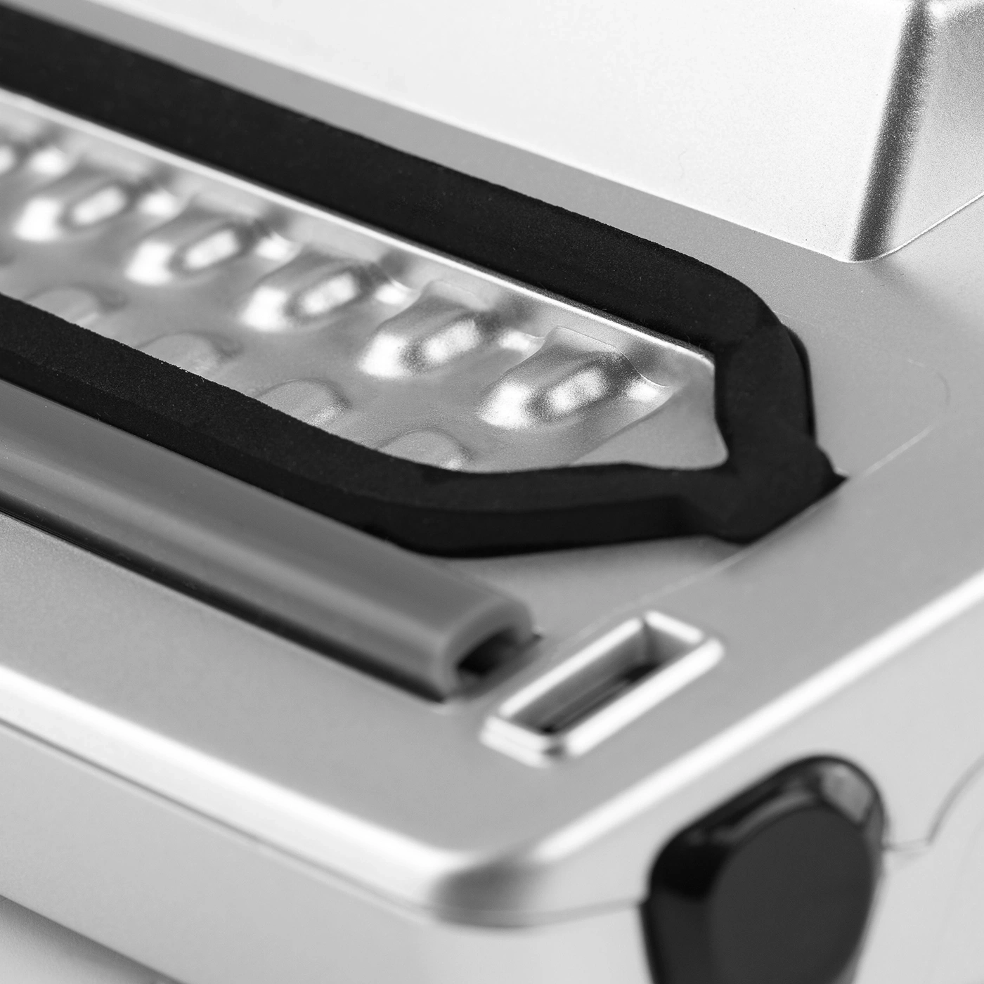 Close-up of a silver device with black rubber and buttons