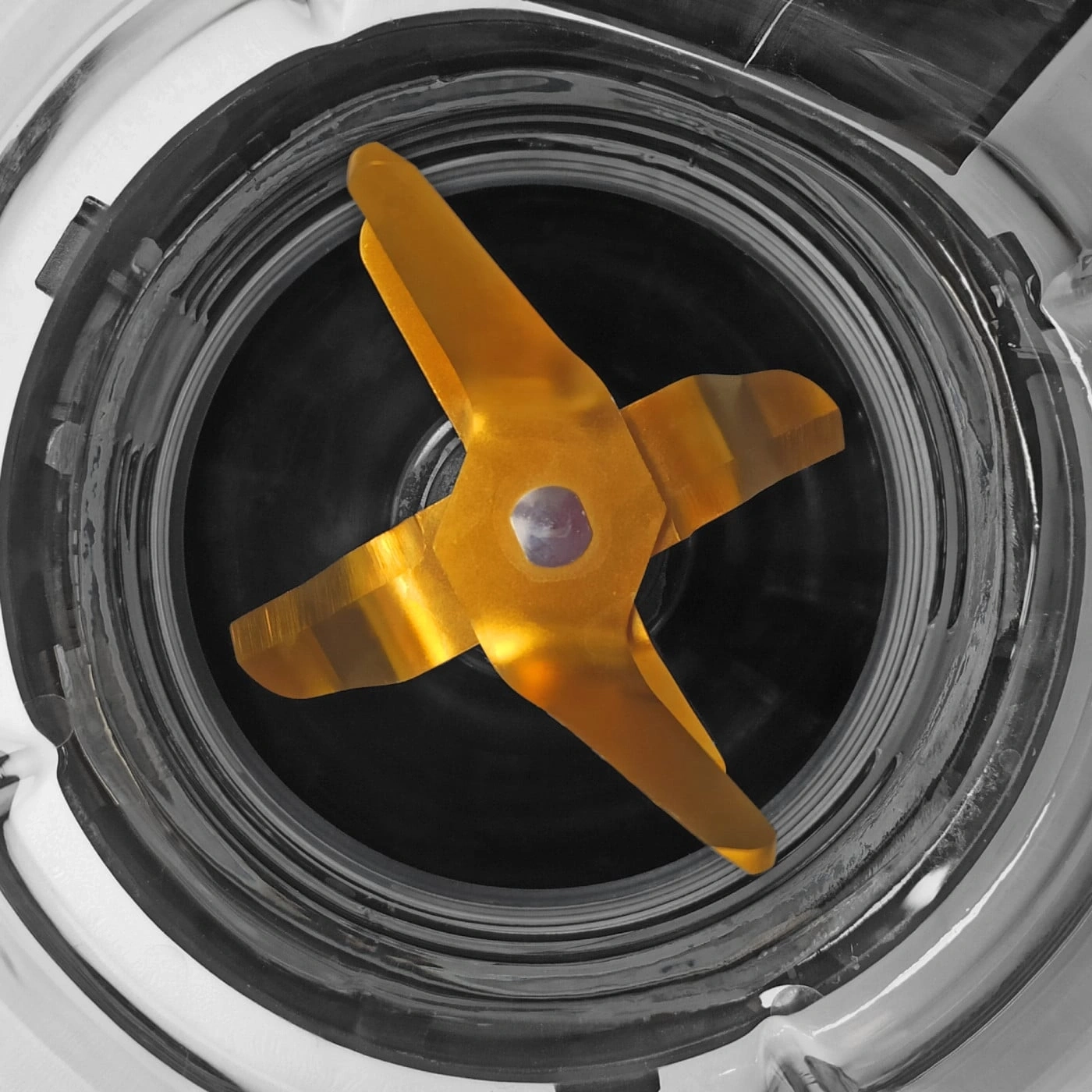 Close-up of a blender with golden blades and a glass container