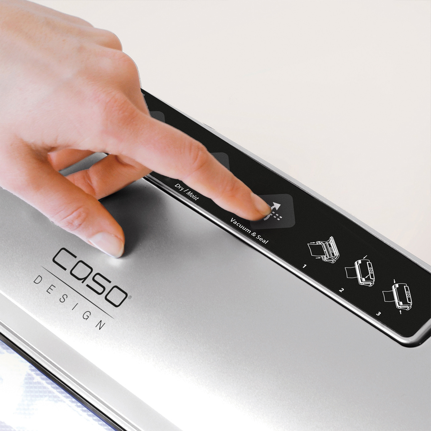 Hand pressing the Vacuum & Seal button on a Caso Design appliance.