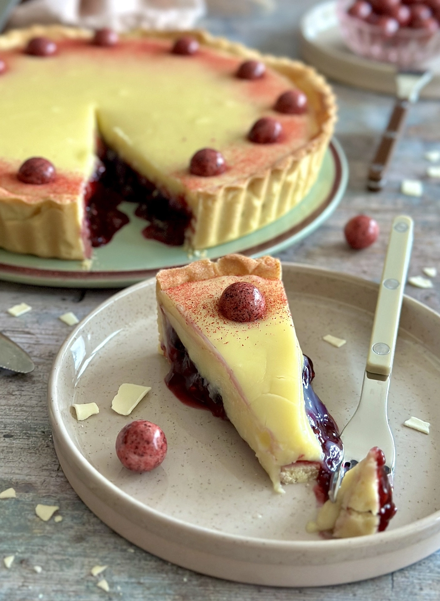 Delicious tart with berries and cream, served on a plate with a fork.