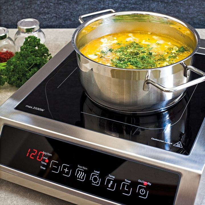 Kochtopf auf Induktionskochfeld mit Suppe. Anzeige zeigt 120 Grad und Timer.