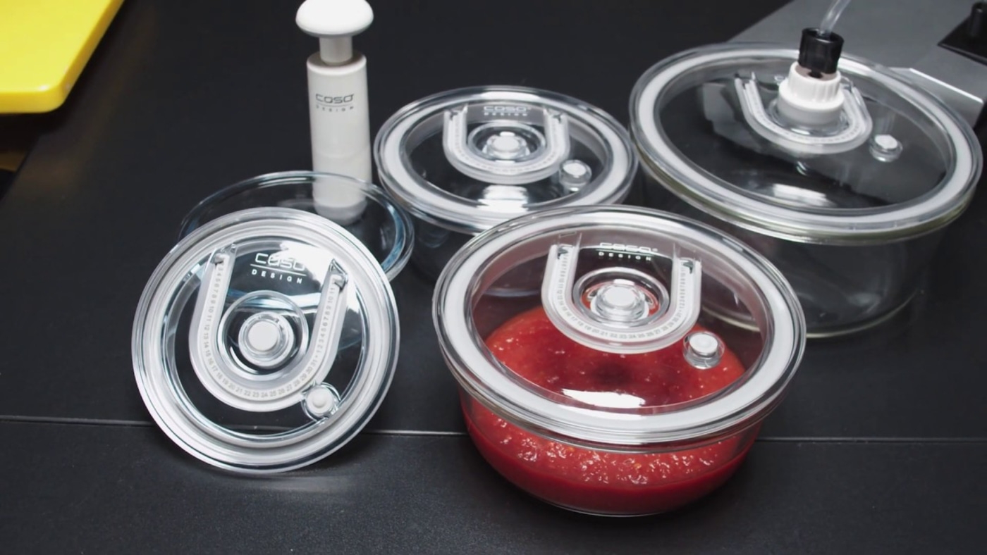 Vacuum containers with pump and red sauce on a black background.