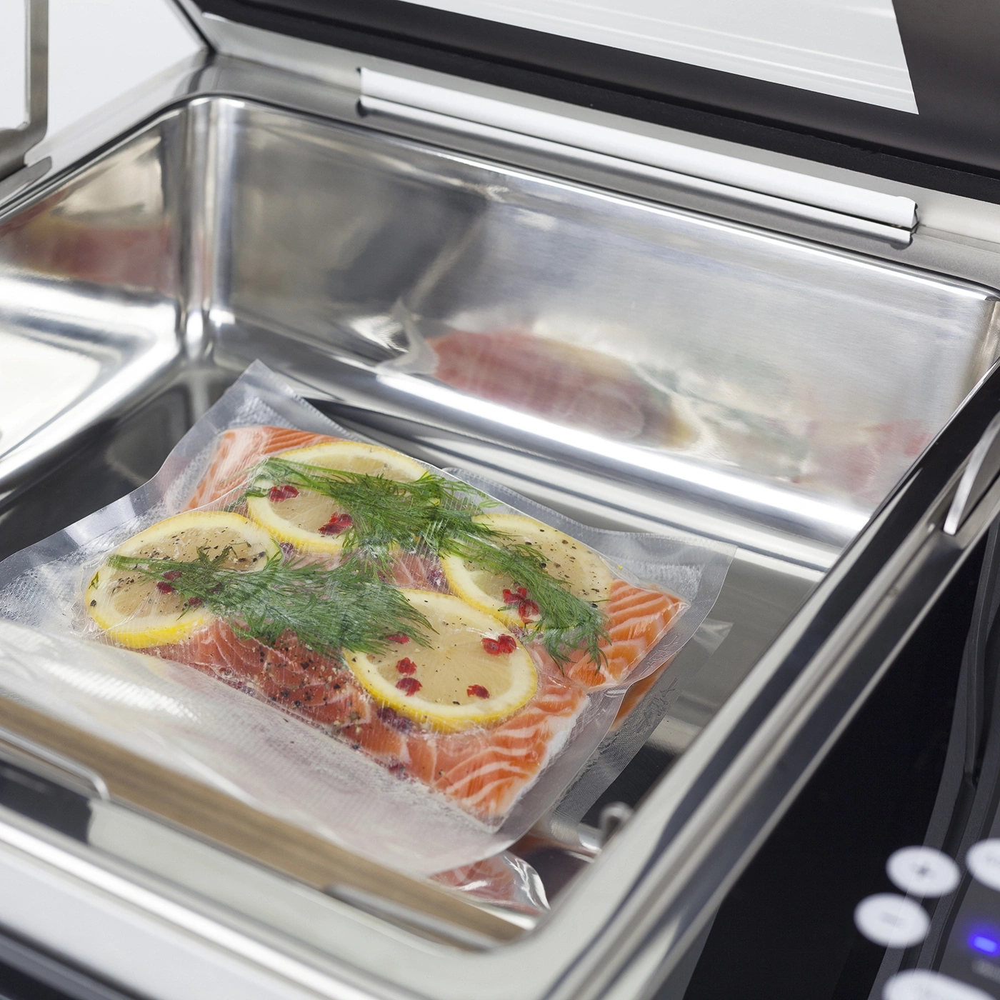 Lachsfilet mit Zitrone und Dill in Vakuumverpackung in einem Vakuumiergerät