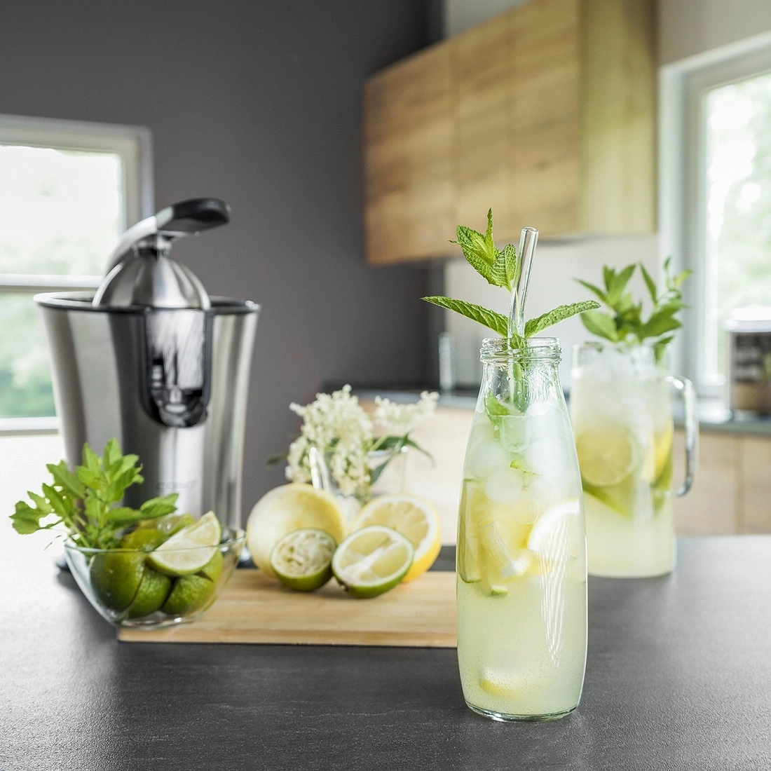 Erfrischendes Getränk mit Limetten, Zitrone und Minze in einer Küche.
