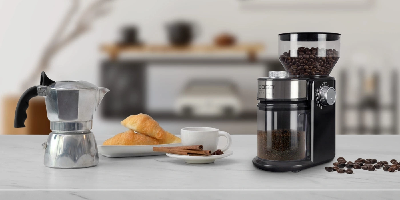 Coffee machine, coffee beans, croissants, cup, cinnamon sticks on the table