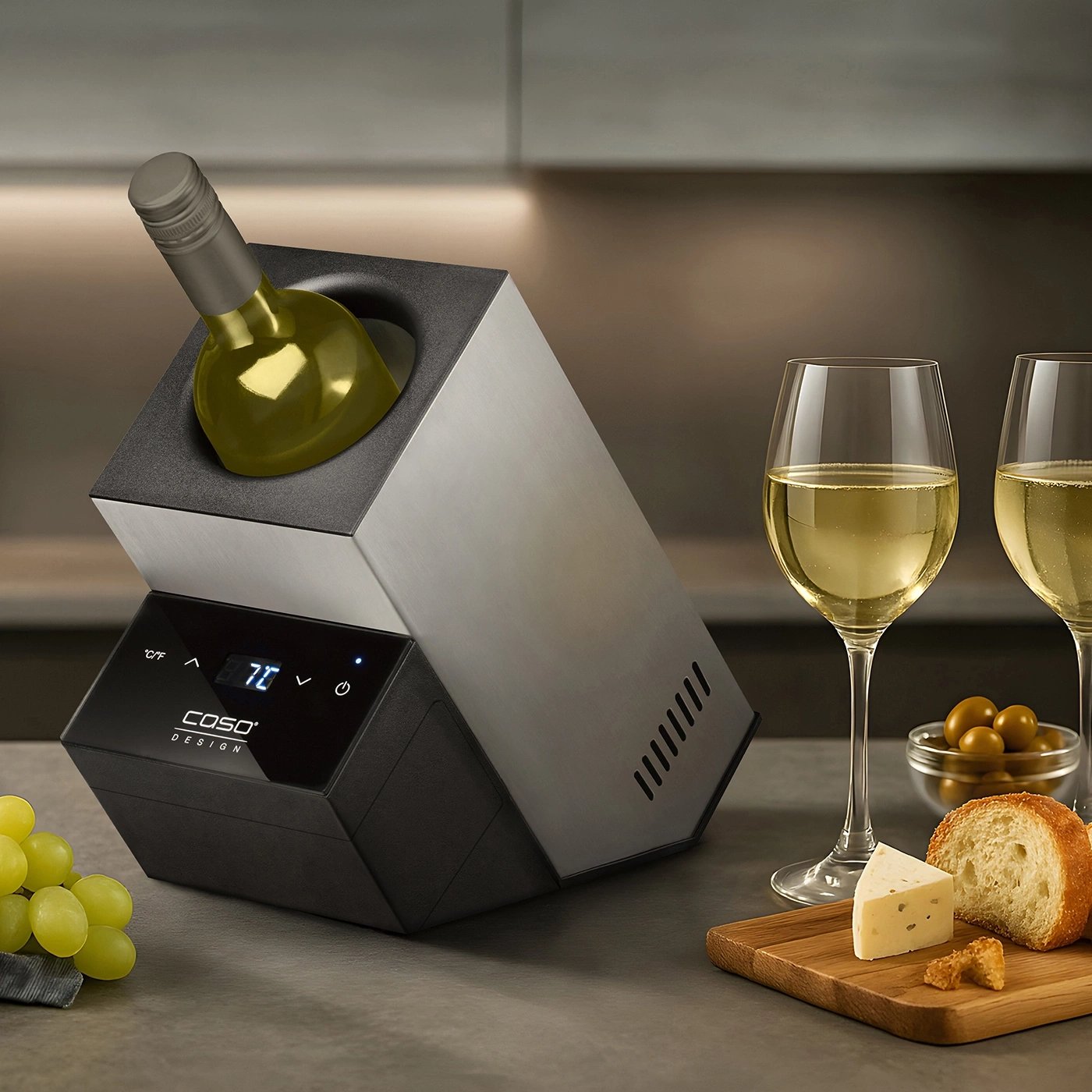 Weinkühler mit Wein, Gläsern, Käse, Brot und Oliven auf einem Tisch.