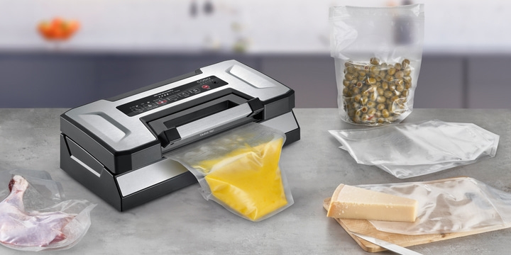 Vacuum sealer with food items in bags on a countertop surface
