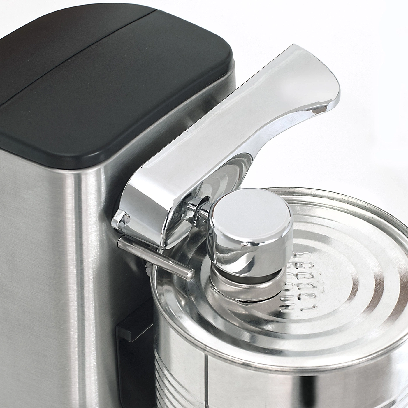 Close-up of an electric can opener with a can being opened, shiny metal.
