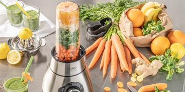 Gesunde Zutaten für einen Smoothie: Karotten, Orangen, Bananen, Ingwer und Zitrone.