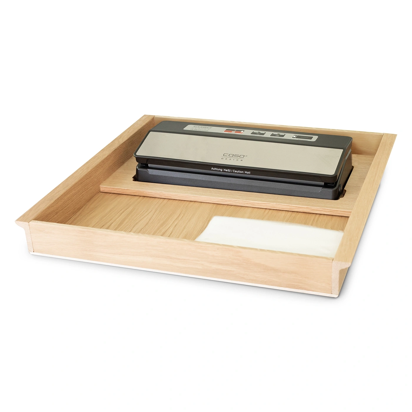 A Caso vacuum sealer rests in a wooden tray with a white cloth.