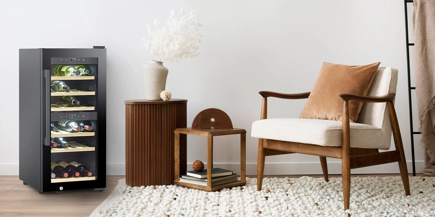 A modern wine cooler next to an armchair and side tables.