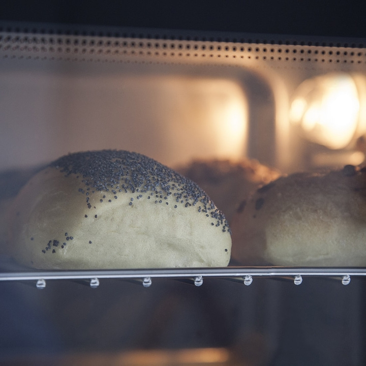 Bread rolls with poppy seeds in an oven. Baking bread. Close-up shot.