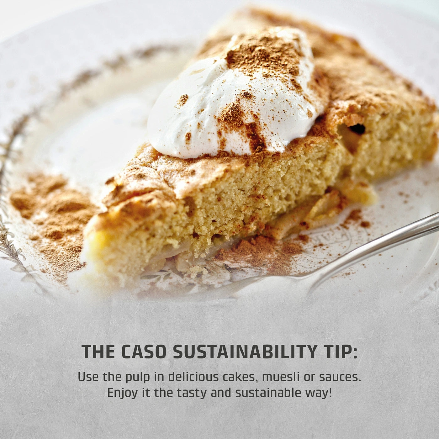 A slice of apple cake with cream and cinnamon sprinkled on a plate.