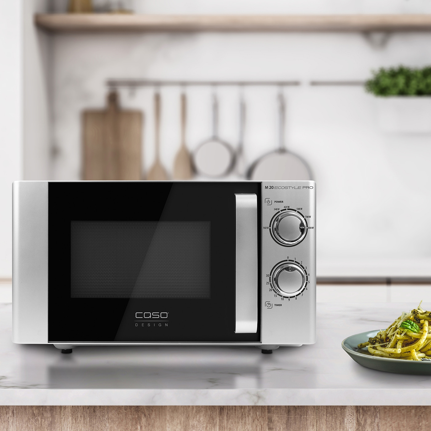 Caso Design M 20 microwave, silver, with cooking surface and pasta on a plate.