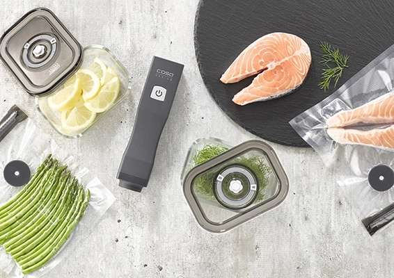 Vakuumiergerät mit Lachs, Zitronen, Dill und Spargel