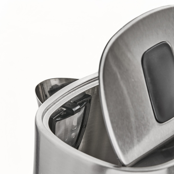 Close-up of a stainless steel kettle with an open lid and tea infuser.
