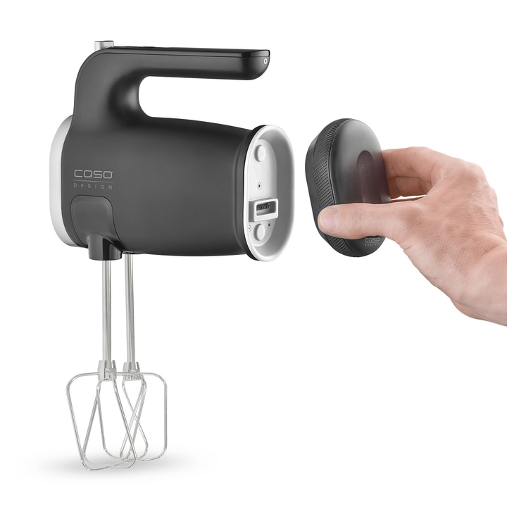 Hand mixer with detachable part held by hand, isolated on white background