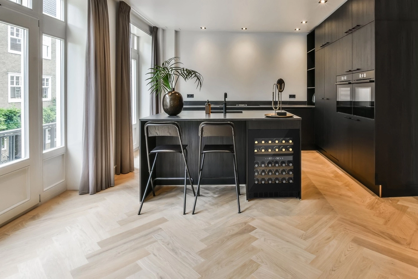 Modern kitchen with wine cooler, bar stools, and herringbone floor