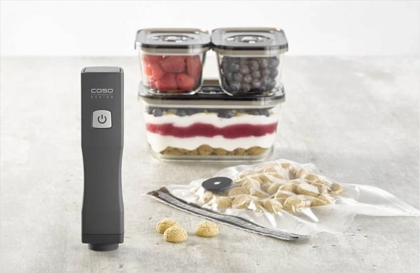 A vacuum sealer with berry desserts and cookies in a bag.