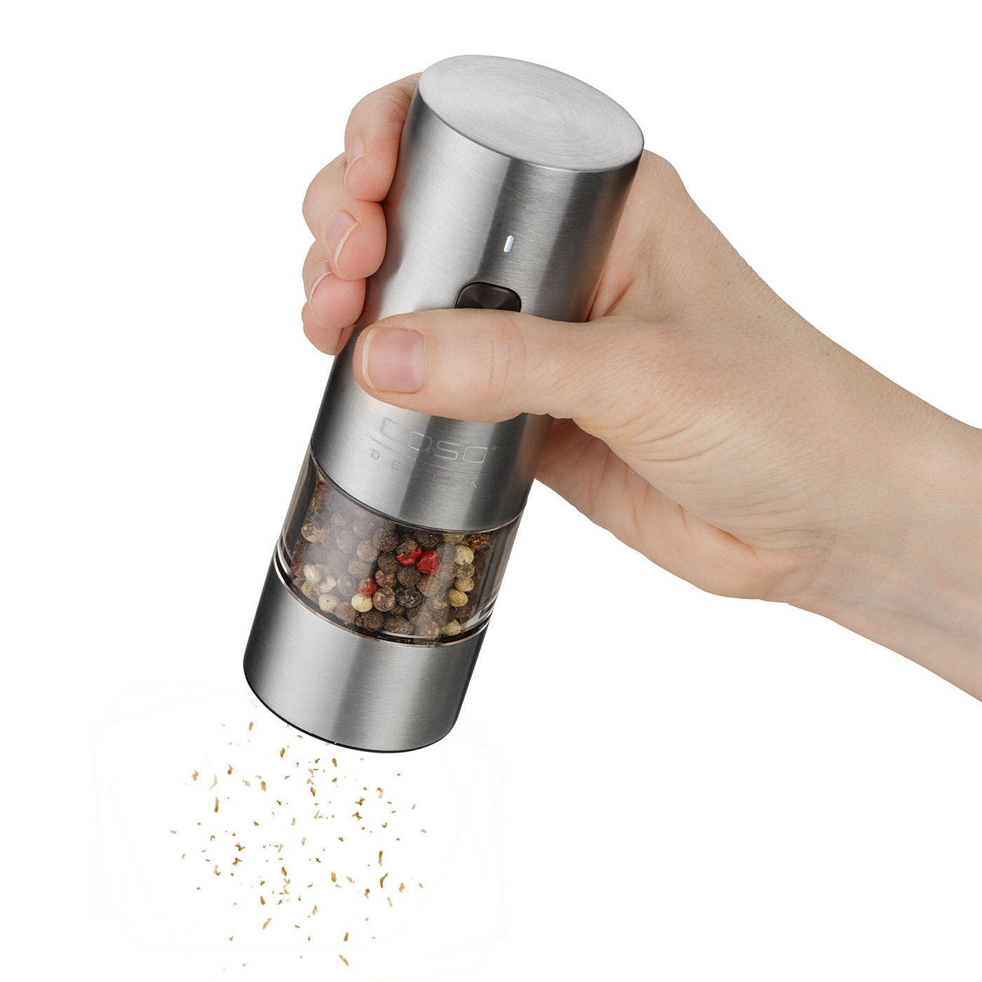 Person holding an electric pepper grinder, grinding and dispensing pepper.