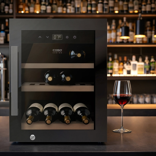 Ein moderner Weinkühlschrank mit Flaschen und einem Weinglas auf der Theke.
