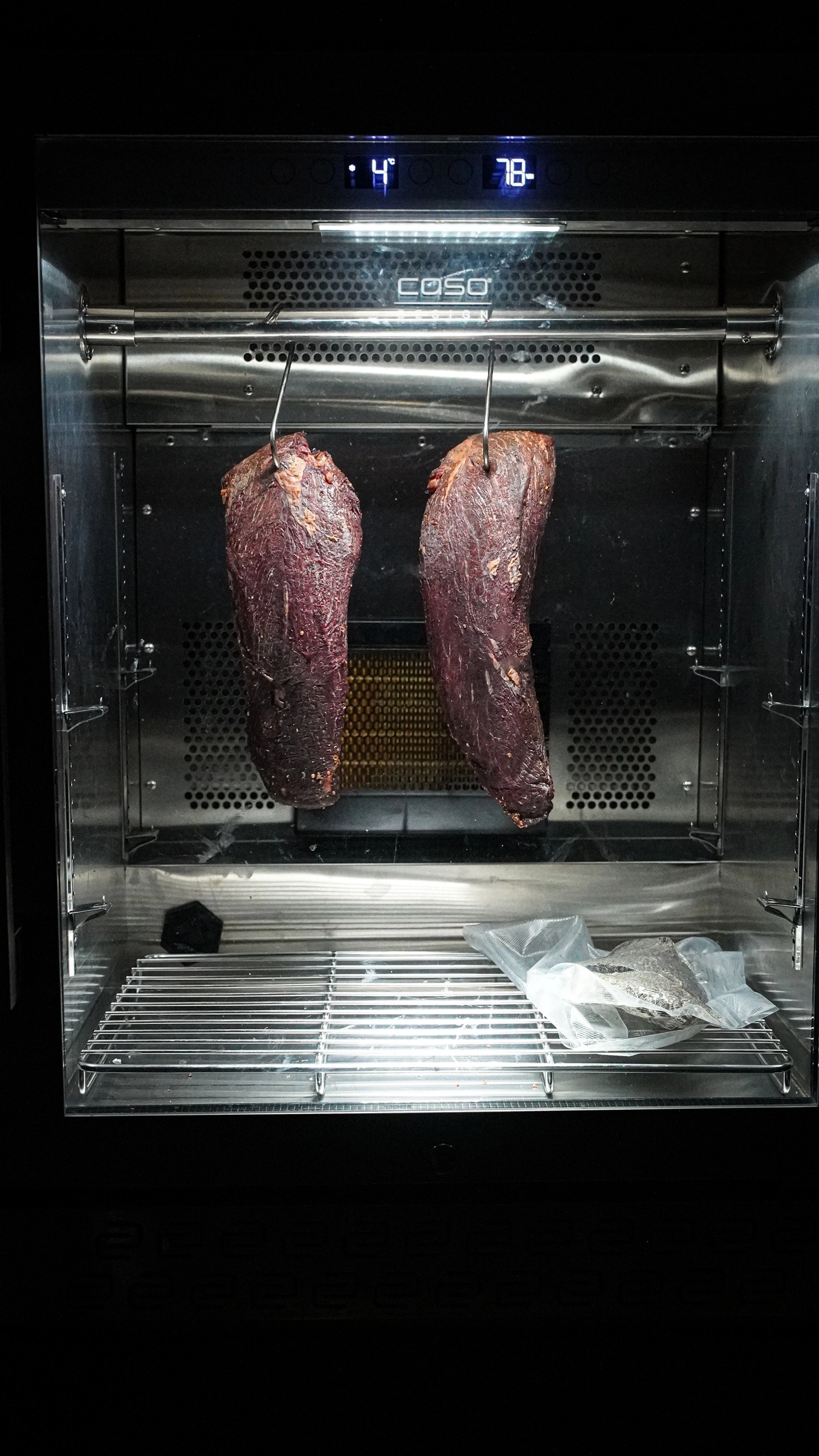Meat hanging in a curing cabinet for drying at 4 degrees Celsius.