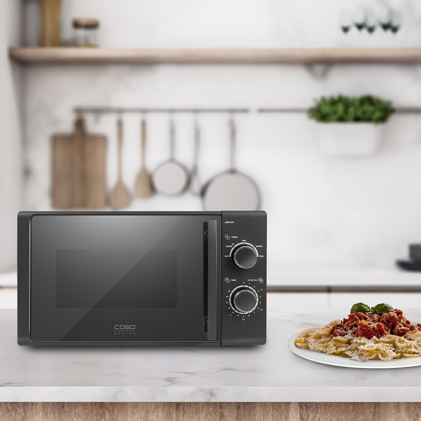 Black microwave with food on a table in a kitchen setting