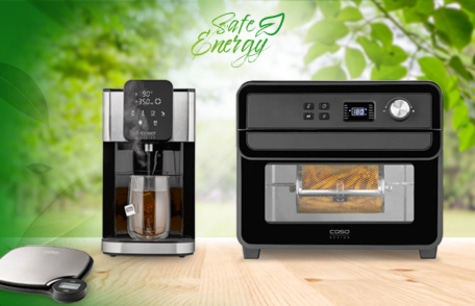 Kitchen appliances: kettle and air fryer on a wooden surface with green background