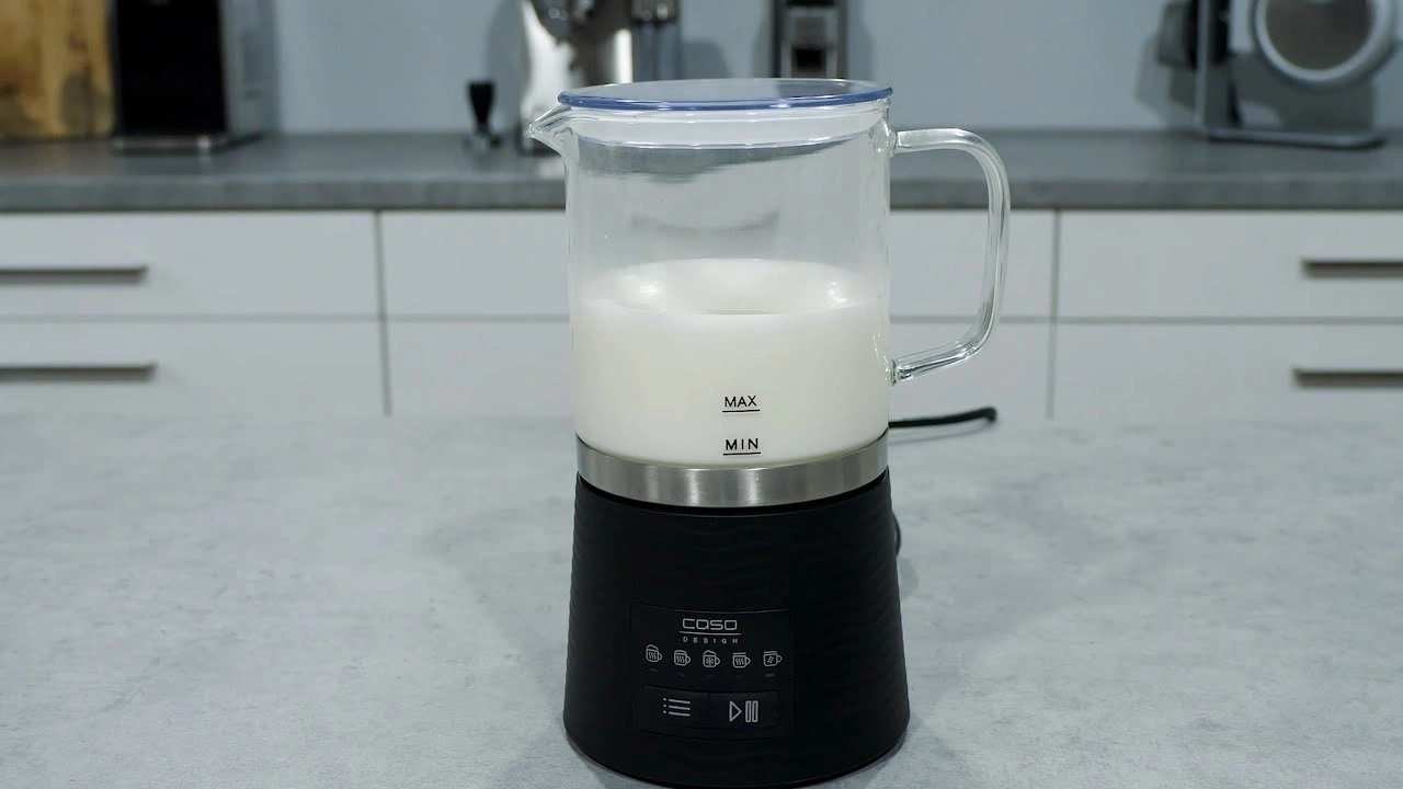 Milchaufschäumer mit Milch auf einer Küchenarbeitsplatte