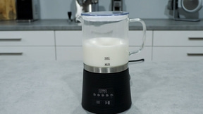 Milchaufschäumer mit Milch auf einer Küchenarbeitsplatte