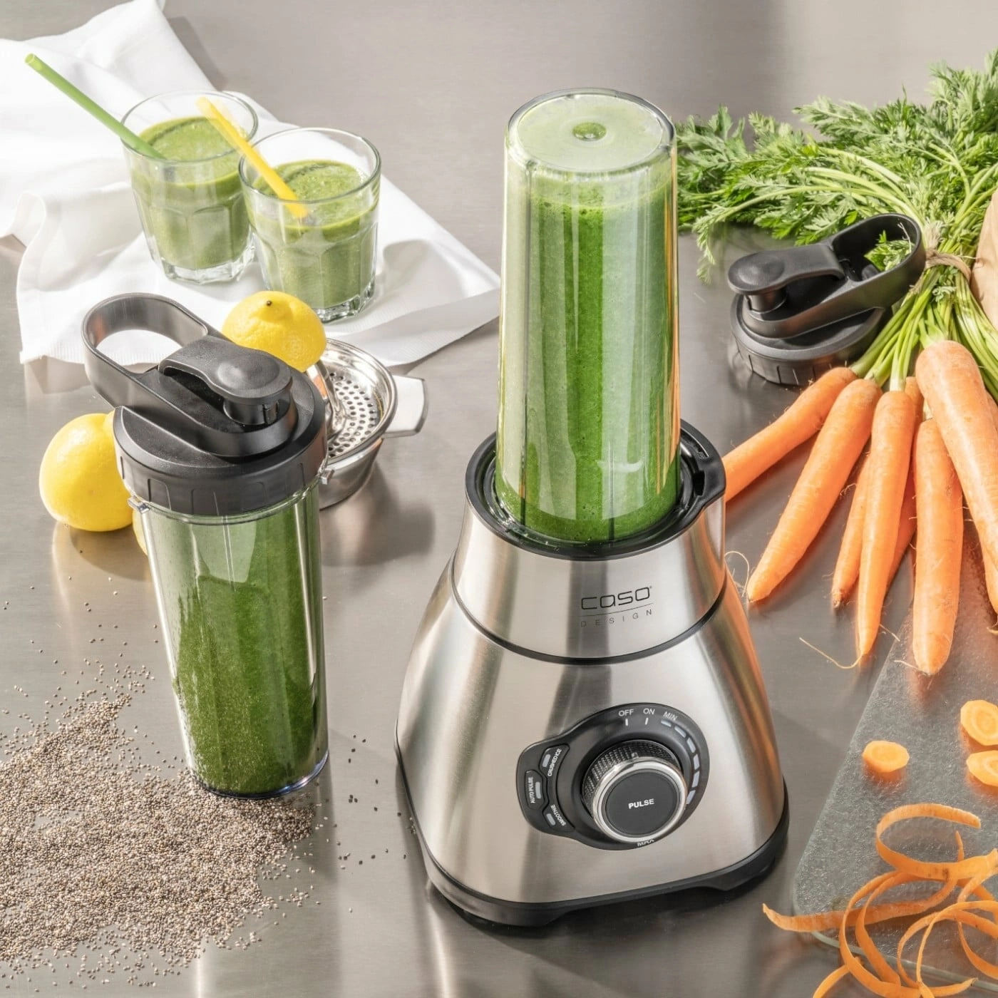 Smoothie-Zubereitung: Mixer, Gläser, Karotten, Zitronen, Chia-Samen, gesunde Ernährung.