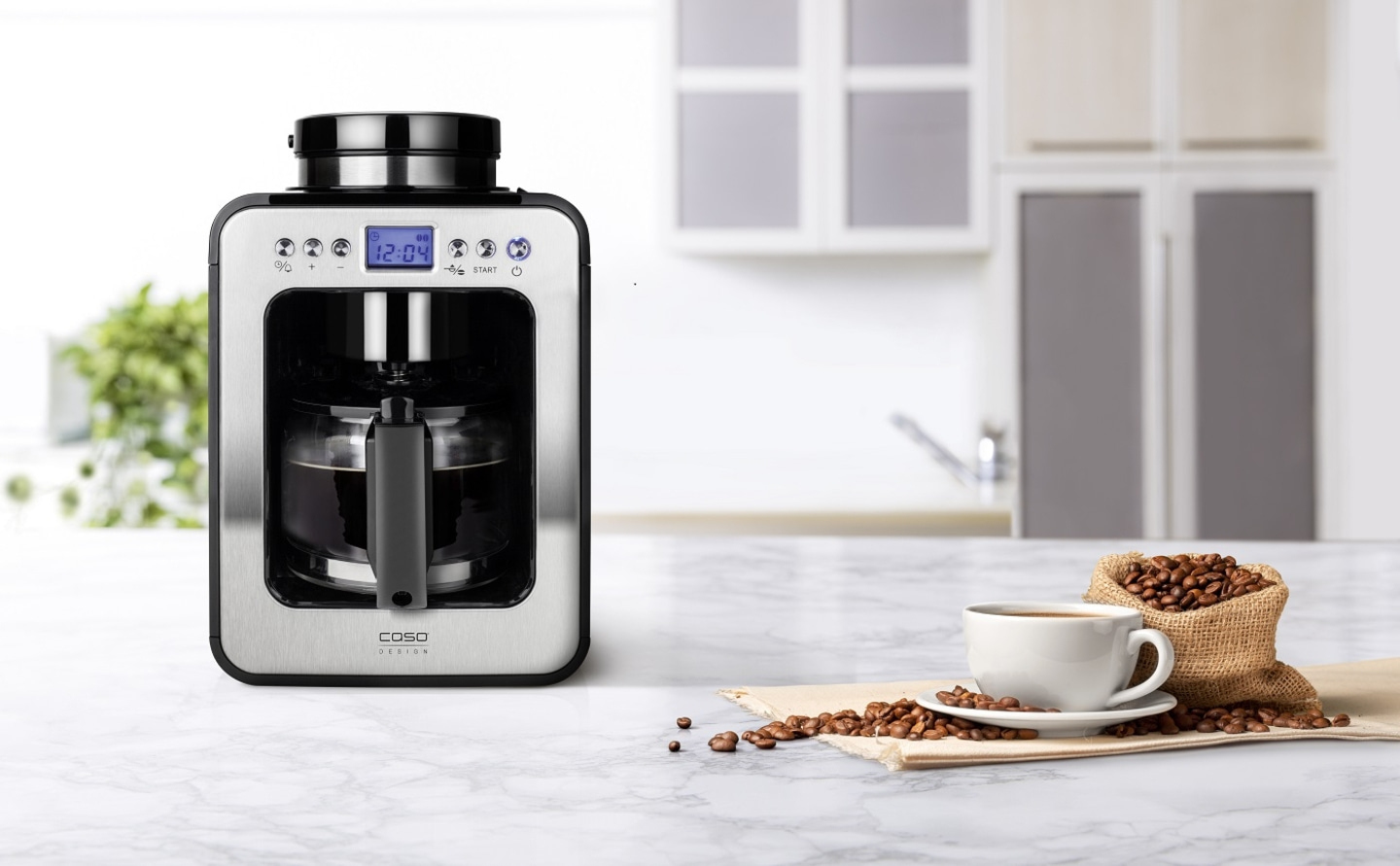 Kaffeemaschine mit Kaffee und Kaffeebohnen auf einem Tisch in der Küche.
