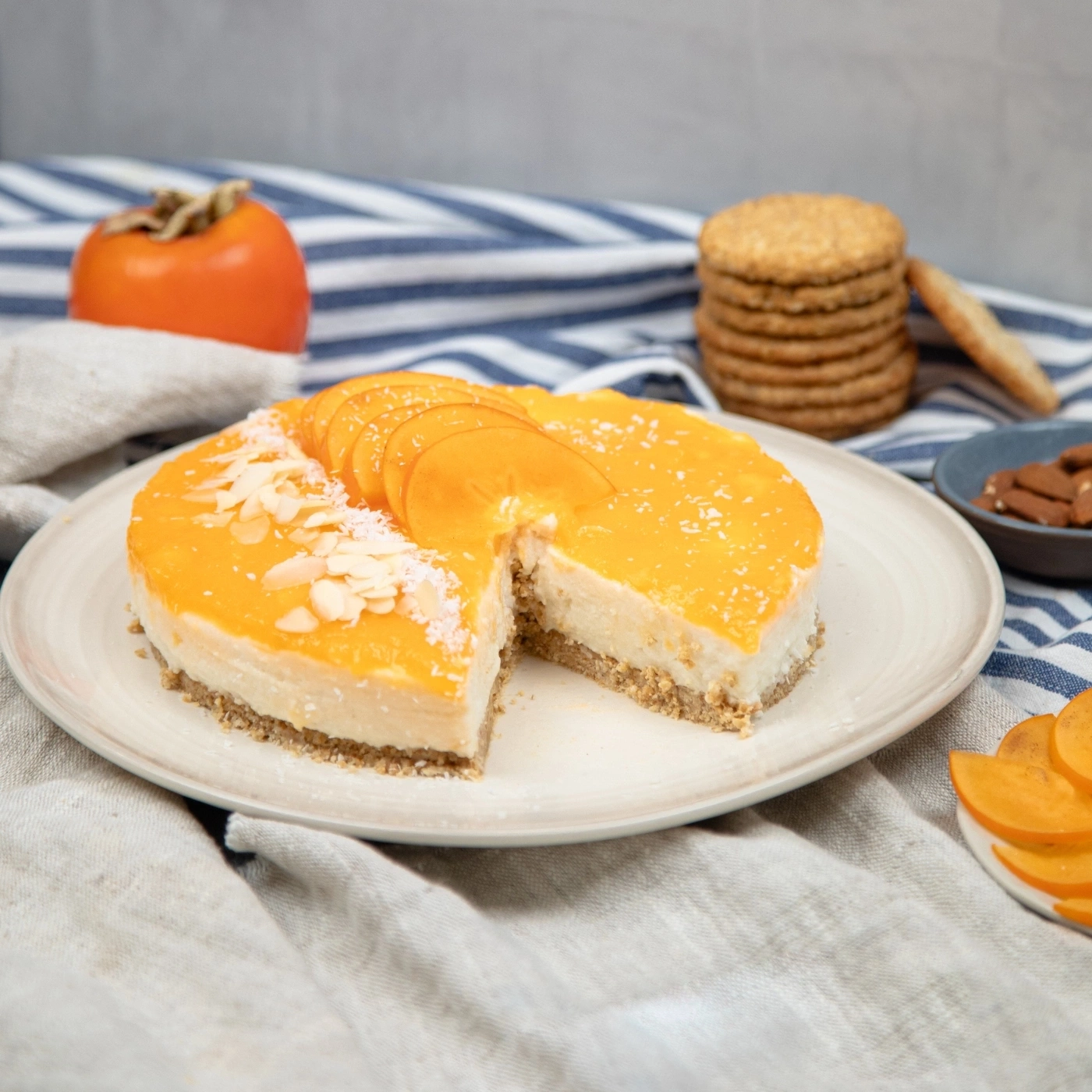 A sliced persimmon cheesecake topped with almond slivers and coconut flakes.