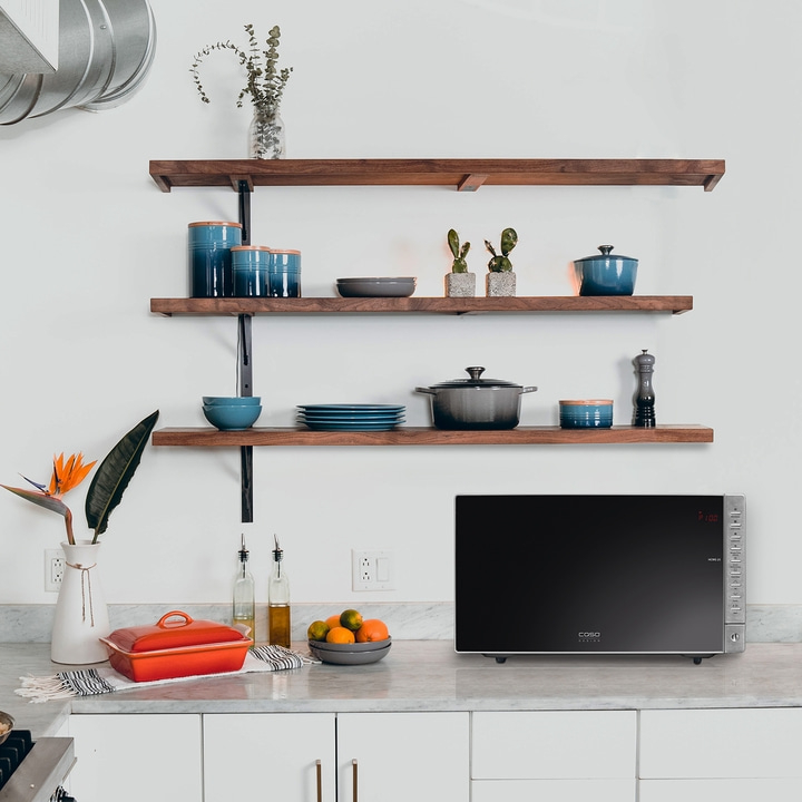 Kitchen with microwave, shelves, and decor. Modern design and aesthetic.