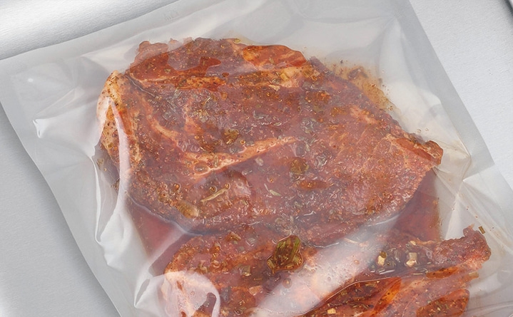 Mariniertes Fleisch in einer Plastiktüte, bereit zum Kochen, Nahaufnahme