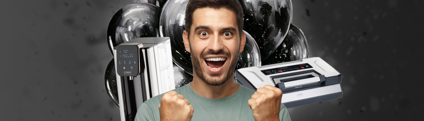Excited man holding kitchen appliances towards the camera against a black background.
