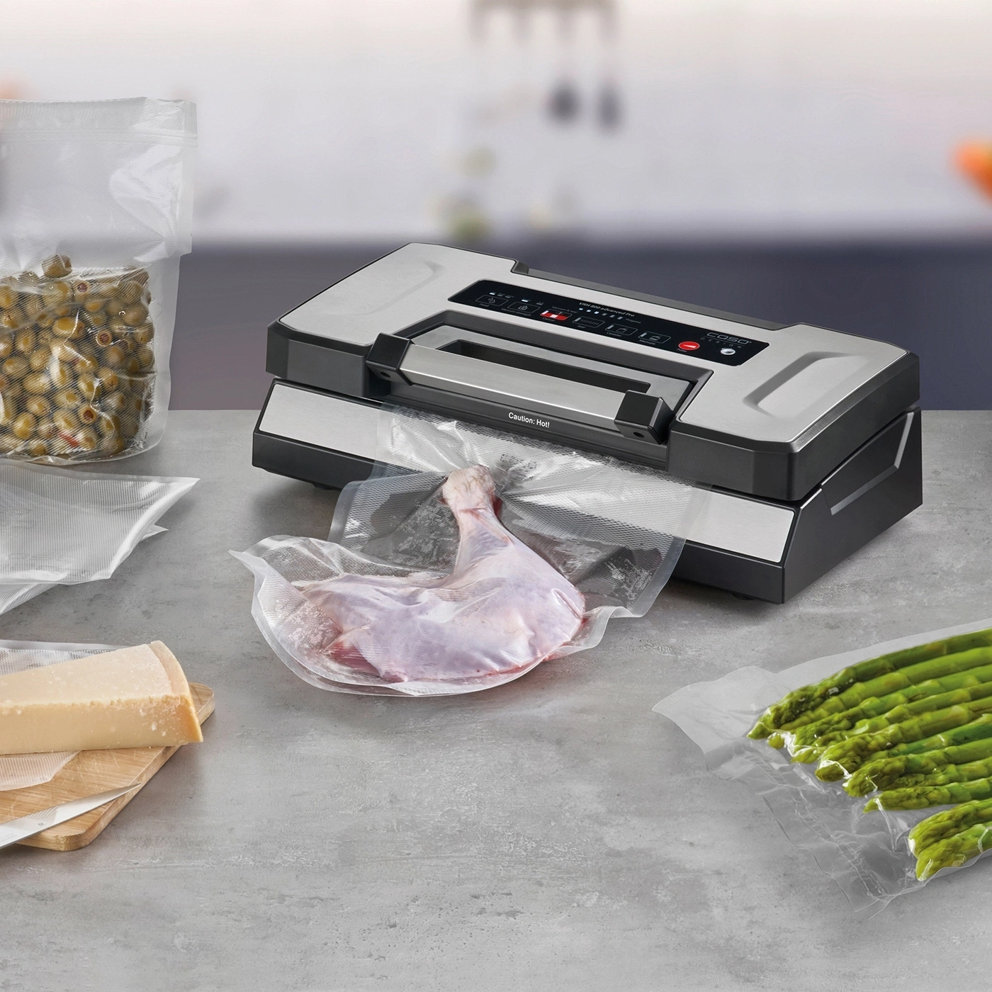 Vacuum sealer with meat, cheese, olives, and asparagus