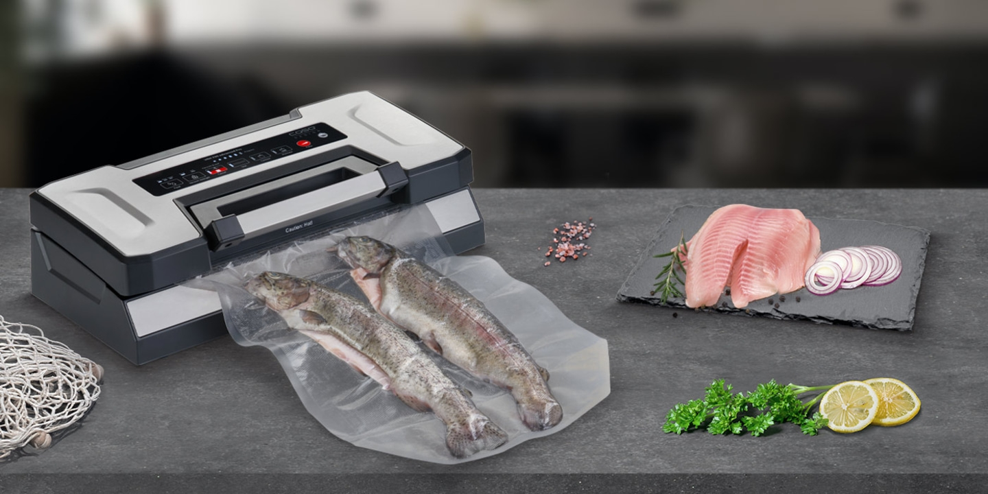 Vacuum sealer with fish and ingredients on a dark surface
