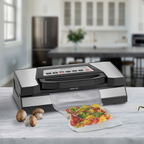 Vacuum sealer with vegetables and mushrooms on a kitchen countertop